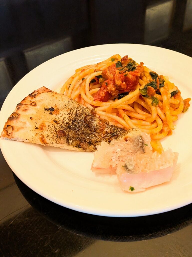 トマトソースのパスタ、焼き立てのピザ、白身魚の料理のプレート
