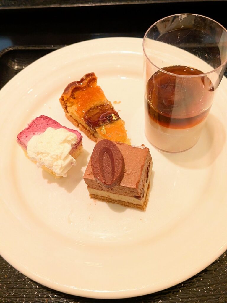 ベリーのムース、フルーツタルト、チョコレートケーキ、グラスデザートのプレート